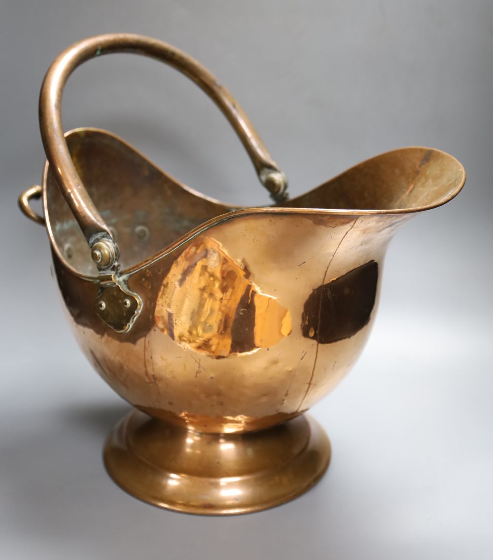 A 19th century planished copper helmet coal scuttle